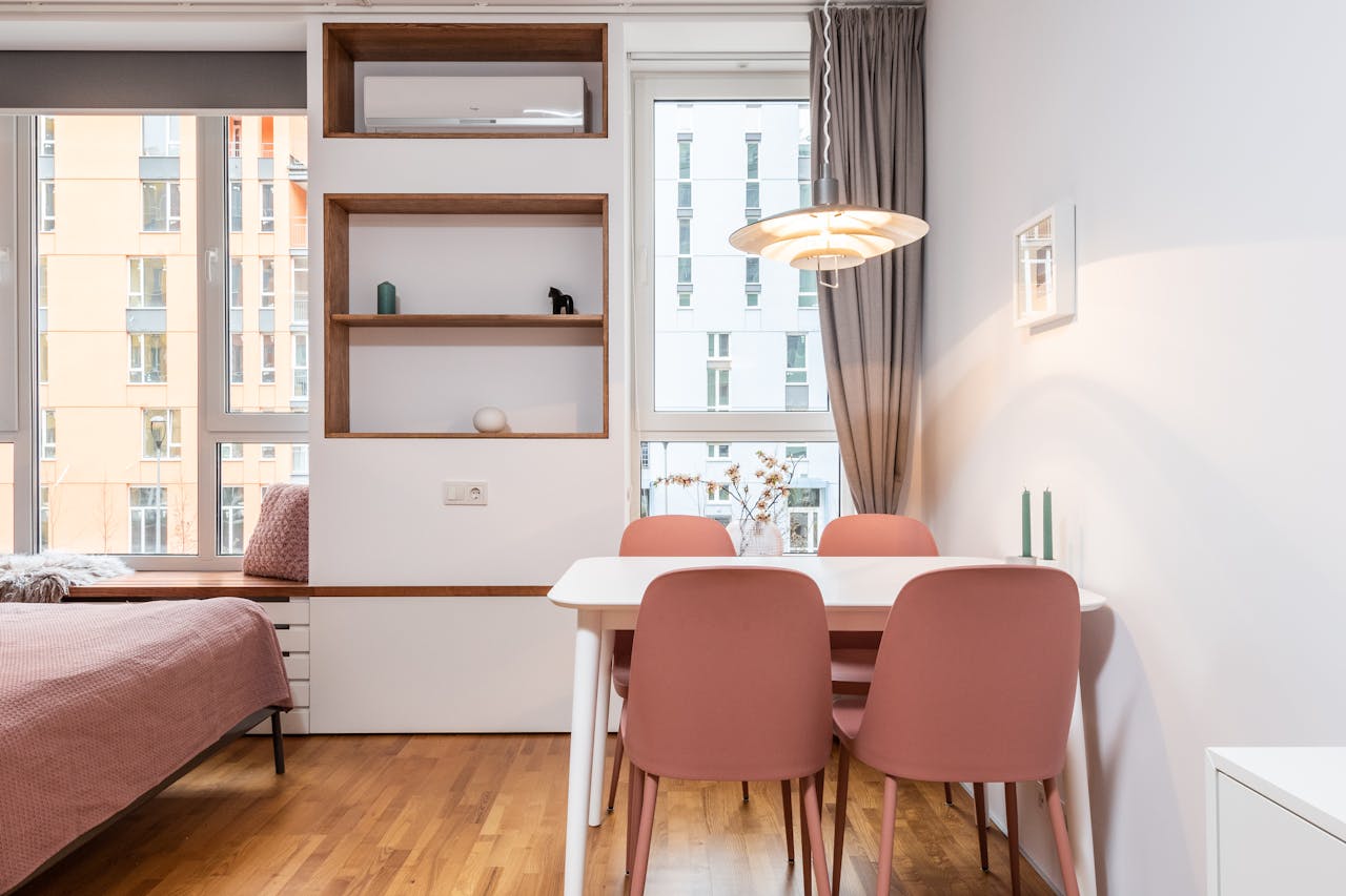 Interior of contemporary comfortable room with bed and chairs with table under luminous lamp